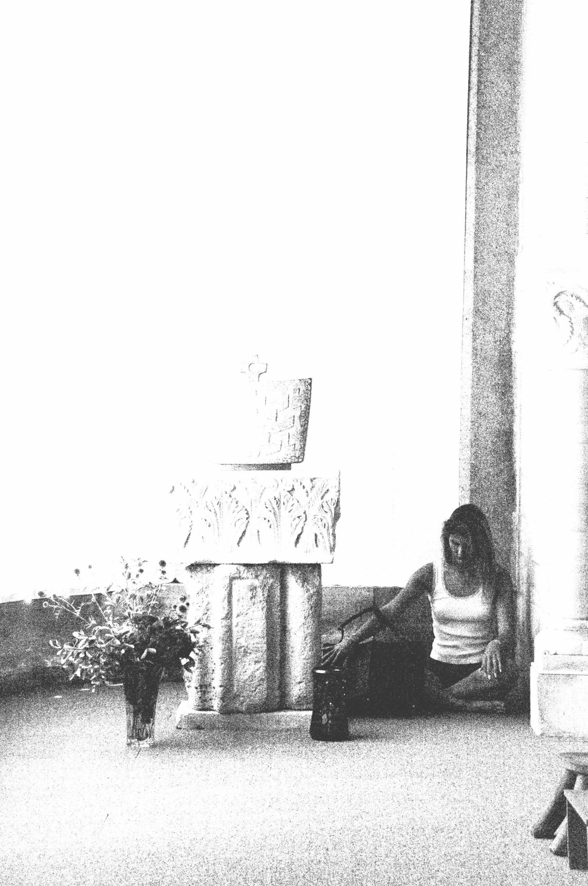 Seated at the foot of a stone column, overexposed