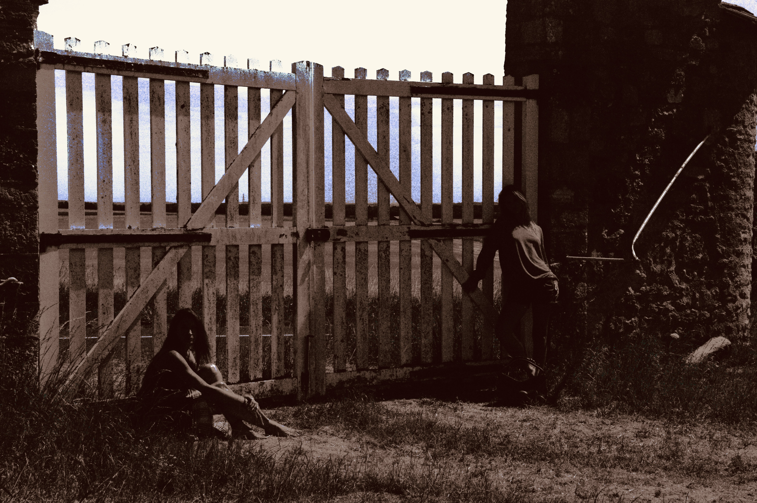 Seated at the wooden gate, sepia
