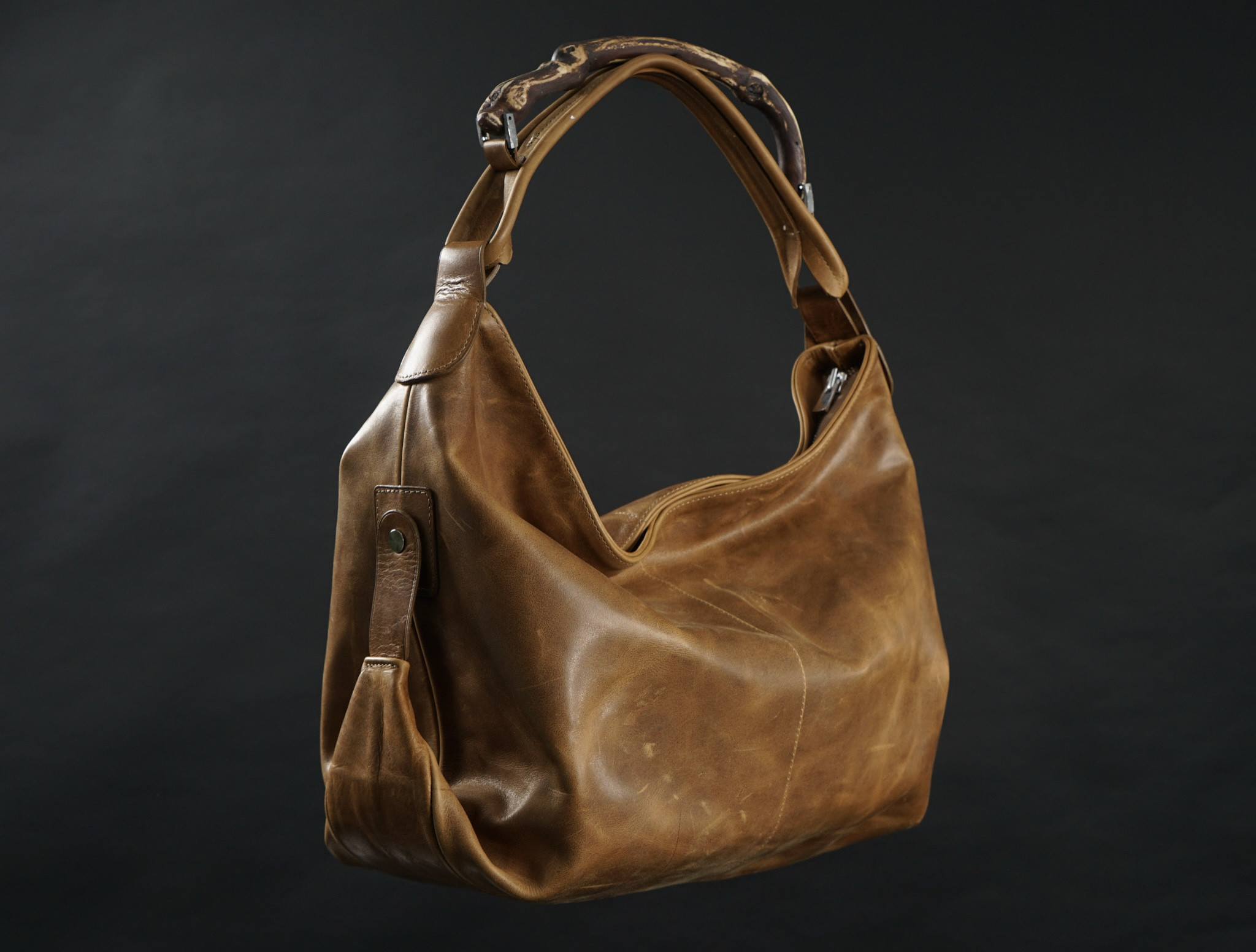 TANIN — waxed brown calfskin bag with vine-wood handle, three-quarter view